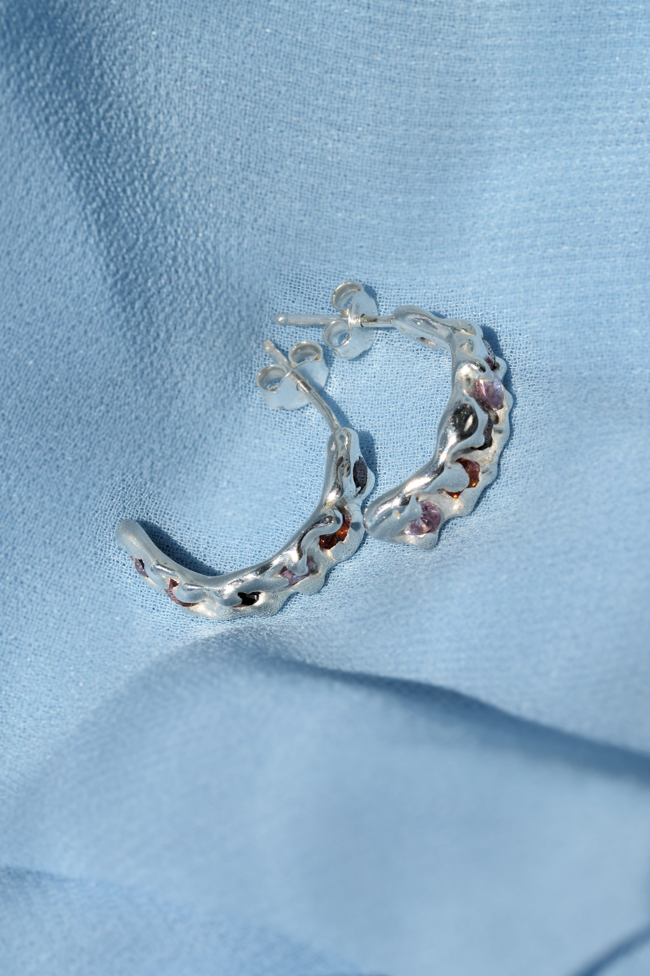 Silver molten textured hoop earrings with cubic zirconias
