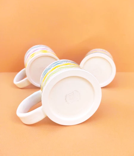 Handmade ceramic mug with colourful patterns